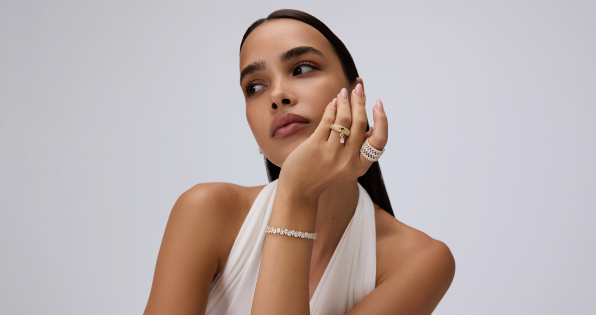 Model wearing layered gold jewelry