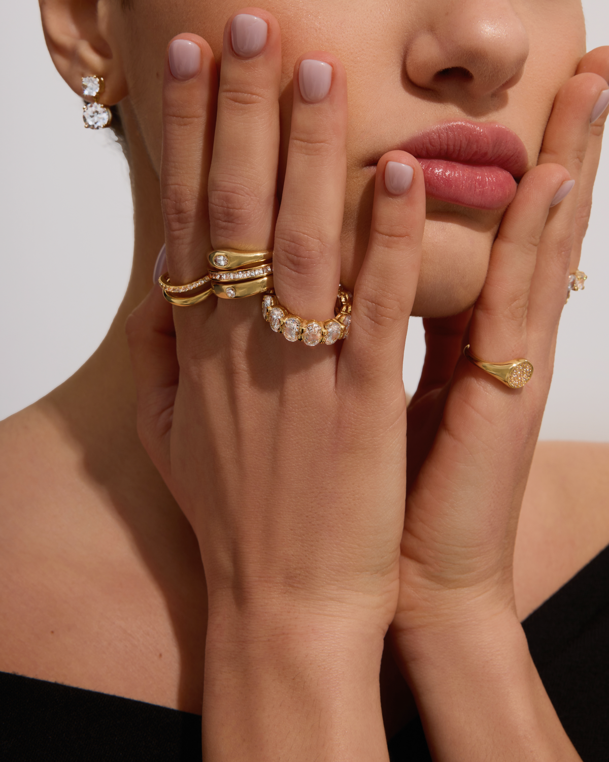 Model wearing gold rings and earrings